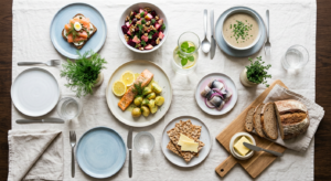A professional, editorial-style flat lay photography of a modern Scandinavian dinner table featuring